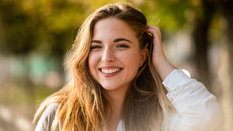 A smiling woman sitting in the park