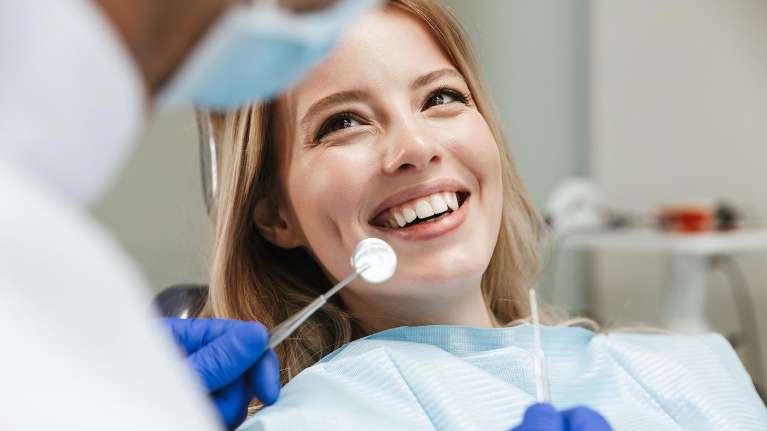 A smiling woman getting a dental exam | Dentist 85262