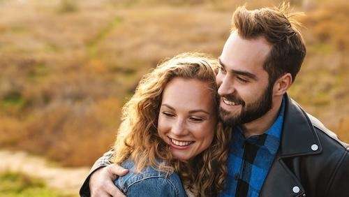 A smiling couple hugging outside | Scottsdale dentist