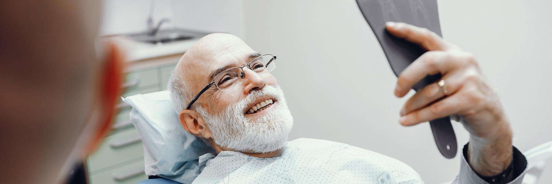A man looking at his smile after a dental exam