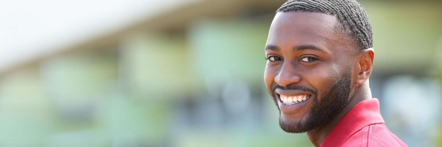 A smiling man with dental crowns looking back