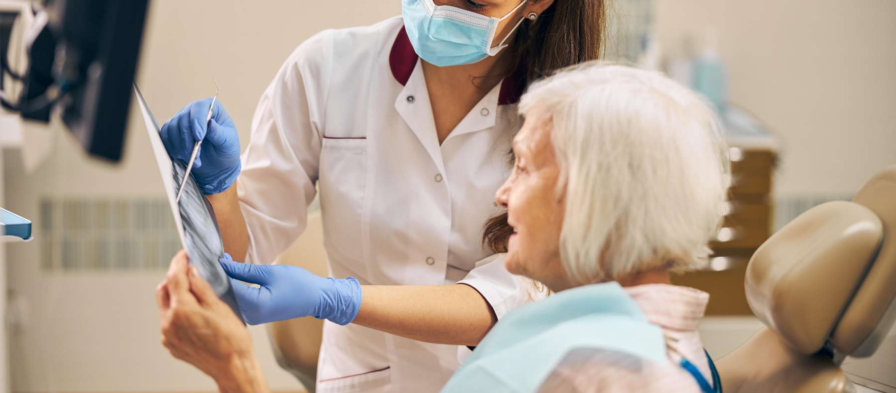A dentist speaking to an elderly patient about her results